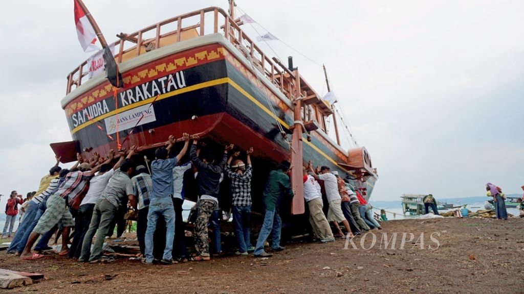 Sejumlah warga berusaha menarik kapal wisata Samudra Krakatau yang akan difungsikan sebagai alat transportasi laut menuju Pulau Pahawang ke tengah laut, Rabu (7/2/2018), di Bandar Lampung, Lampung. 