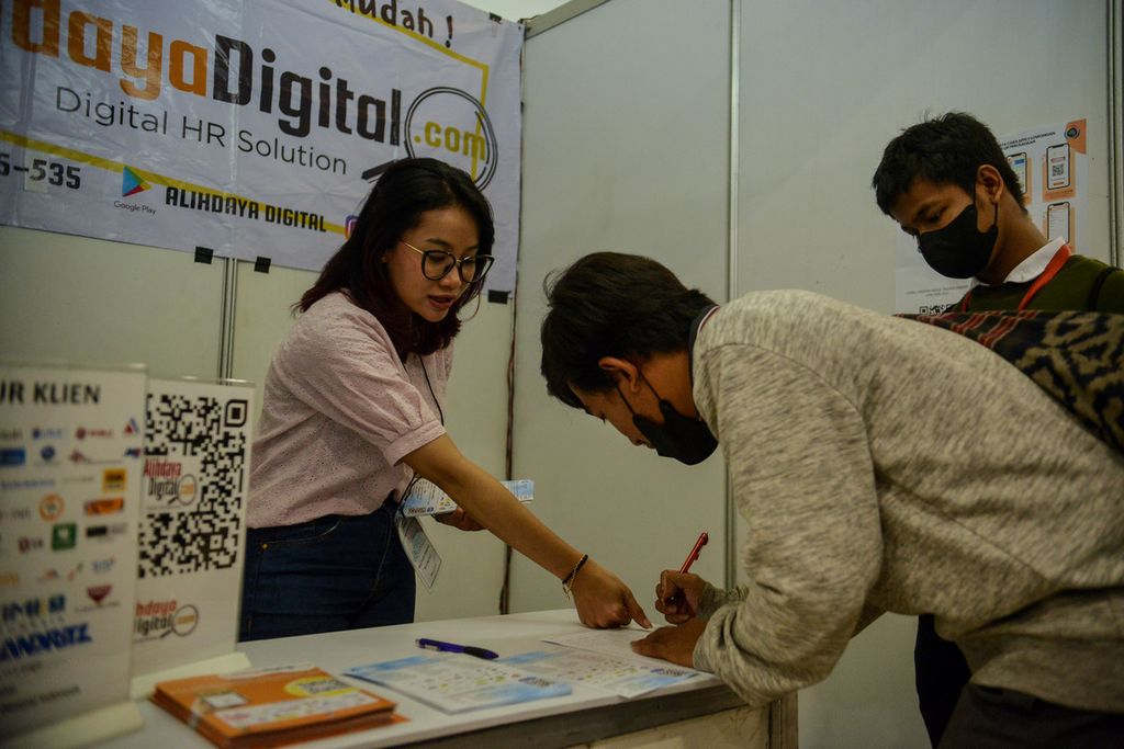 Dua pencari kerja menulis absensi di salah satu stan di acara Jakarta Job Fair 2023 di Plaza Semanggi, Jakarta Selatan, Selasa (30/5/2023). 