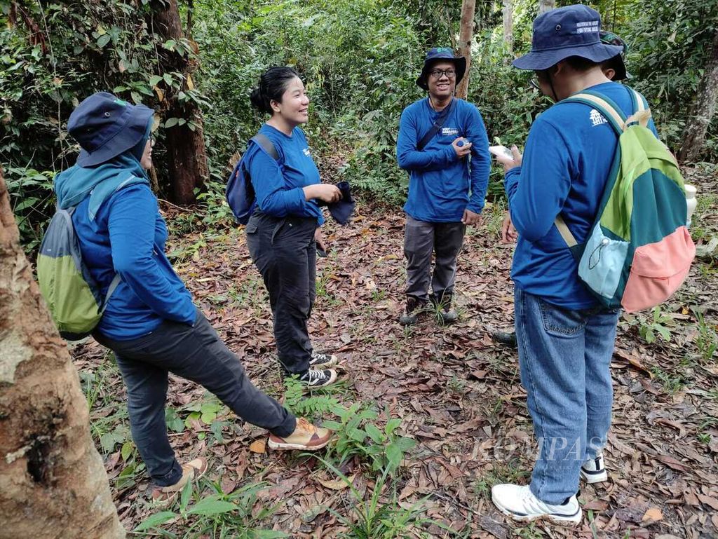 Beberapa peserta Visit Harapan bersenda gurau seusai mengamati aneka flora di Jambi, Jumat (9/2/2024). Mereka sedang mengunjungi Hutan Harapan untuk ikut melestarikannya dengan menanam pohon.