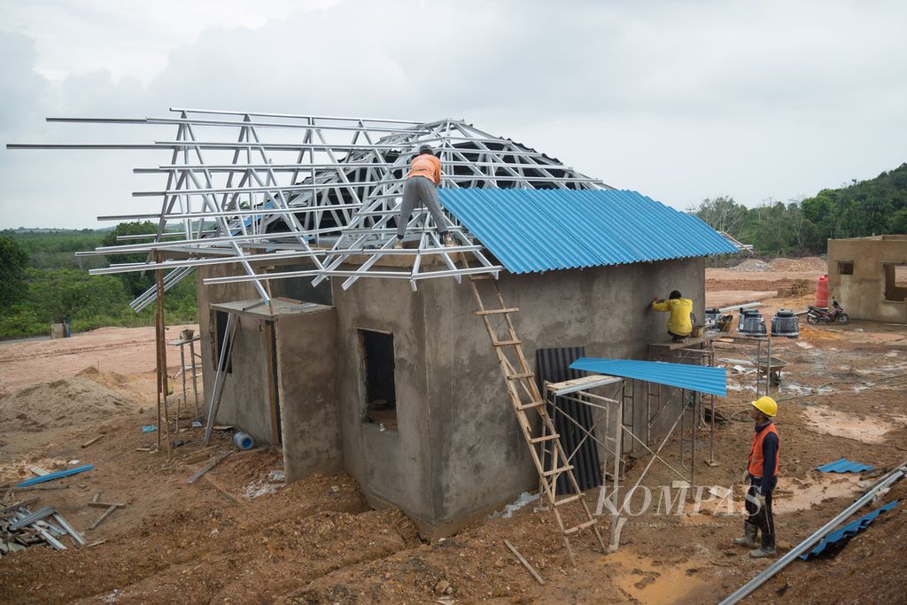 Pekerja memasang atap rumah contoh relokasi warga terdampak pembangunan Proyek Strategis Nasional Rempang Eco City di Kampung Tanjung Banun, Pulau Rempang, Batam, Kepulauan Riau, Selasa (5/3/2024).