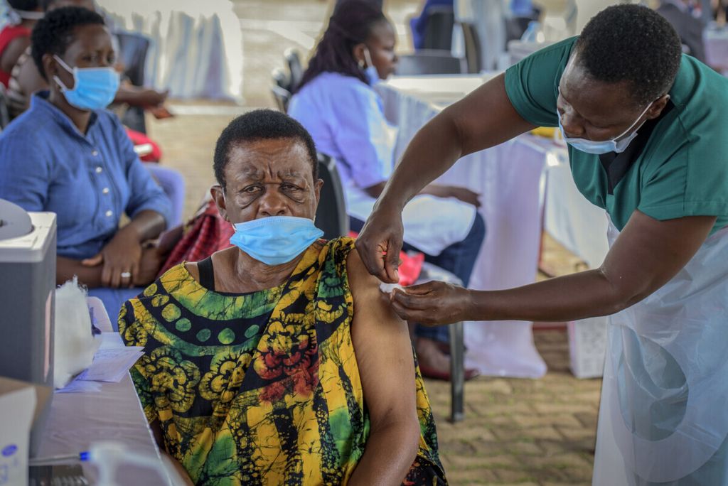 Dalam foto pada 31 Mei 2021, seorang perempuan menerima suntikan vaksin Covid-19 di wilayah Kololo, Kampala, Uganda. 