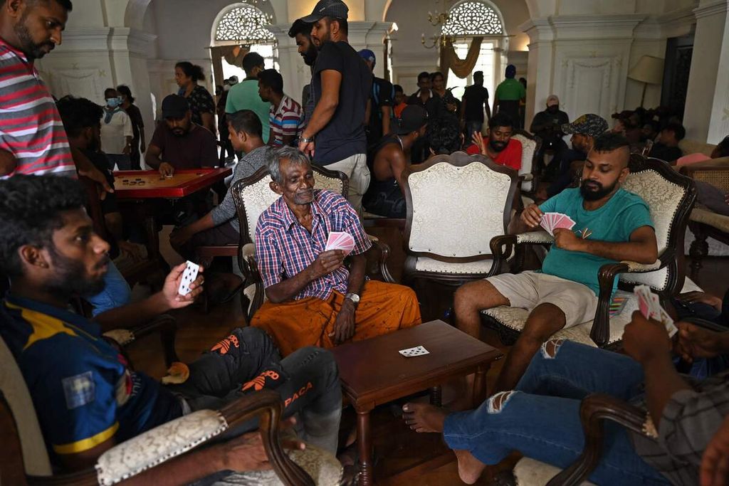 Warga bermain kartu di kediaman resmi Perdana Menteri Sri Lanka di Colombo, Sri Lanka, Minggu (10/7/2022), sehari setelah kediaman tersebut diserbu dan diduduki para pengunjuk rasa. 