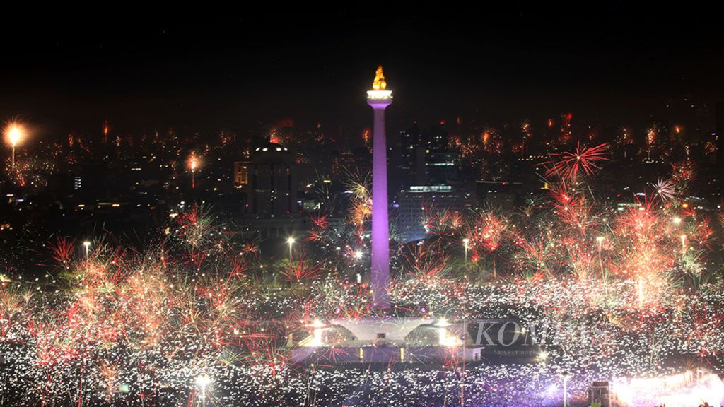 Perayaan Tahun Baru di Monas - Lautan warga dan kembang api menghiasi Monumen Nasional (Monas), Jakarta, saat perayaan Tahun Baru 2018, Selasa (1/1/2018).