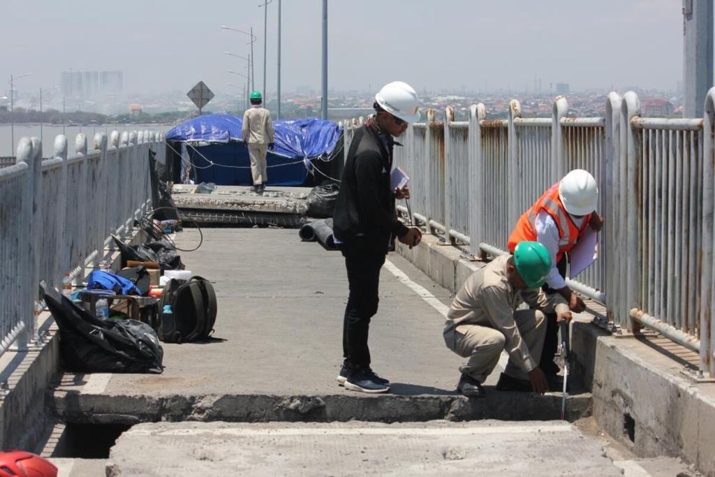 Ilustrasi. Petugas mengukur titik beton yang dibongkar di Jembatan Suramadu, Jawa Timur, Rabu (4/10).