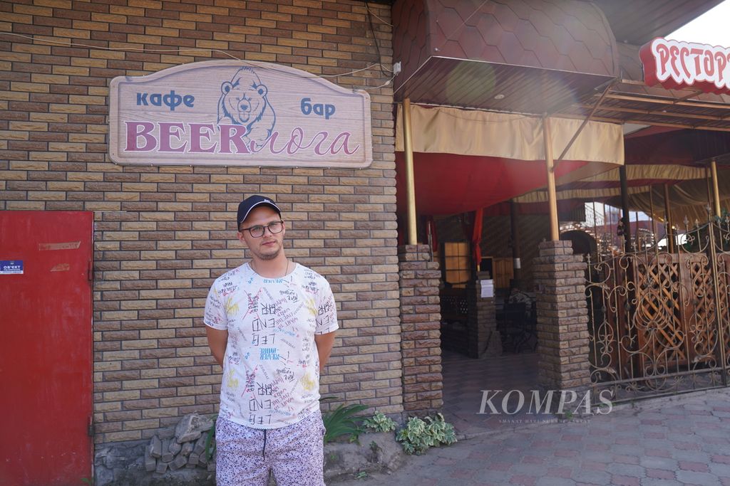 Miroslav Shylo (23) berdiri di depan Beerloga, restoran miliknya, di Kota Trostyanets, Provinsi Sumy, Ukraina (26/6/2022). Pada saat kota Trostyanets dikuasai Rusia, Miroslav membuat roti untuk dibagikan kepada warga. 