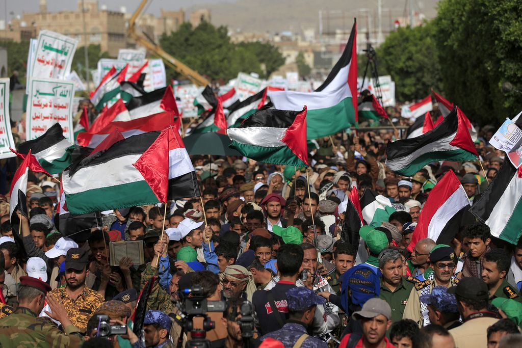  Warga melambaikan bendera Palestina saat turun ke jalan di ibu kota Yaman, Sanaa, yang dikendalikan kelompok Houthi, 7 Oktober 2023. Mereka mendukung serangan kelompok Hamas ke Israel. 