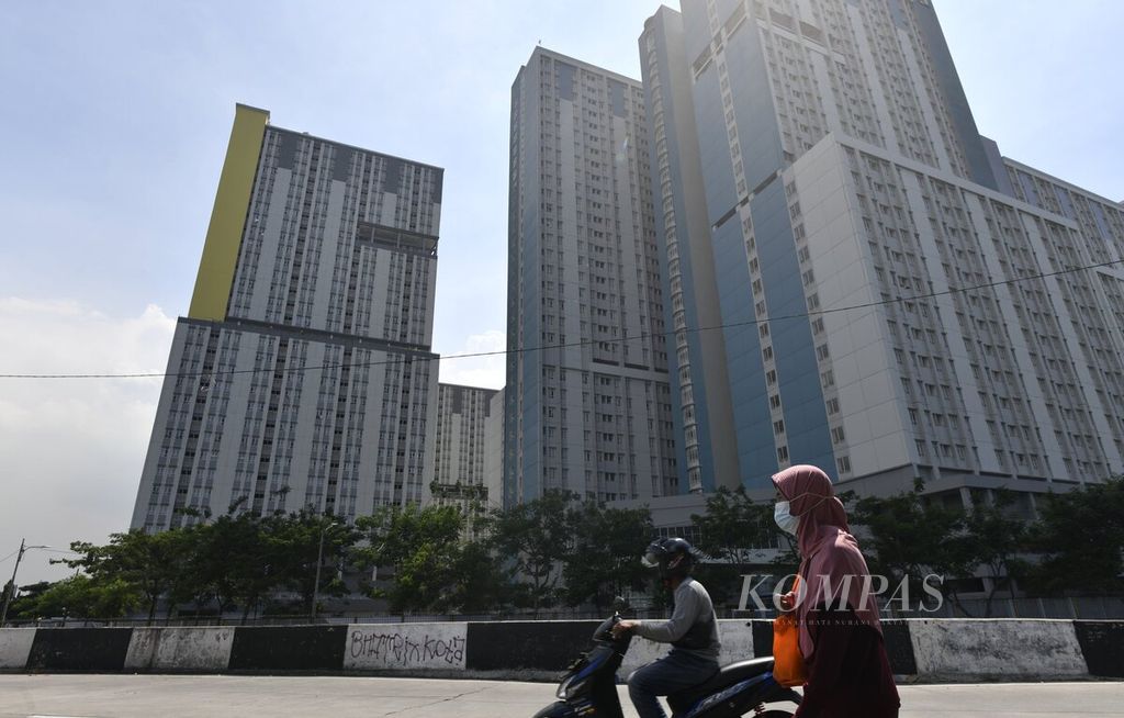 Warga melintas di depan kompleks Rumah Sakit Darurat Covid-19 Wisma Atlet Kemayoran, Jakarta, Rabu (22/12/2021). Kasus Covid-19 terus bertambah seiring dengan meluasnya transmisi lokal varian Omicron di wilayah Jakarta dan sekitarnya.