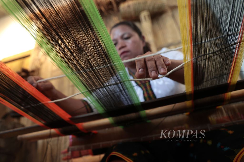 Karolina Andus (47), perajin tenun, mendemontrasikan kemampuannya menenun dalam pameran produk UMKM di obyek wisata Goa Batu Cermin, Labuan Bajo, Manggarai Barat, Sabtu (6/5/2023). Karolina merupakan satu dari 20-an perajin tenun di Kampung Buas, Ngancar, Kecamatan Lembor, Manggarai Barat, yang ditunjuk untuk membuat kain tenun yang akan digunakan para kepala negara dan pasangannya pada KTT Ke-42 ASEAN. 