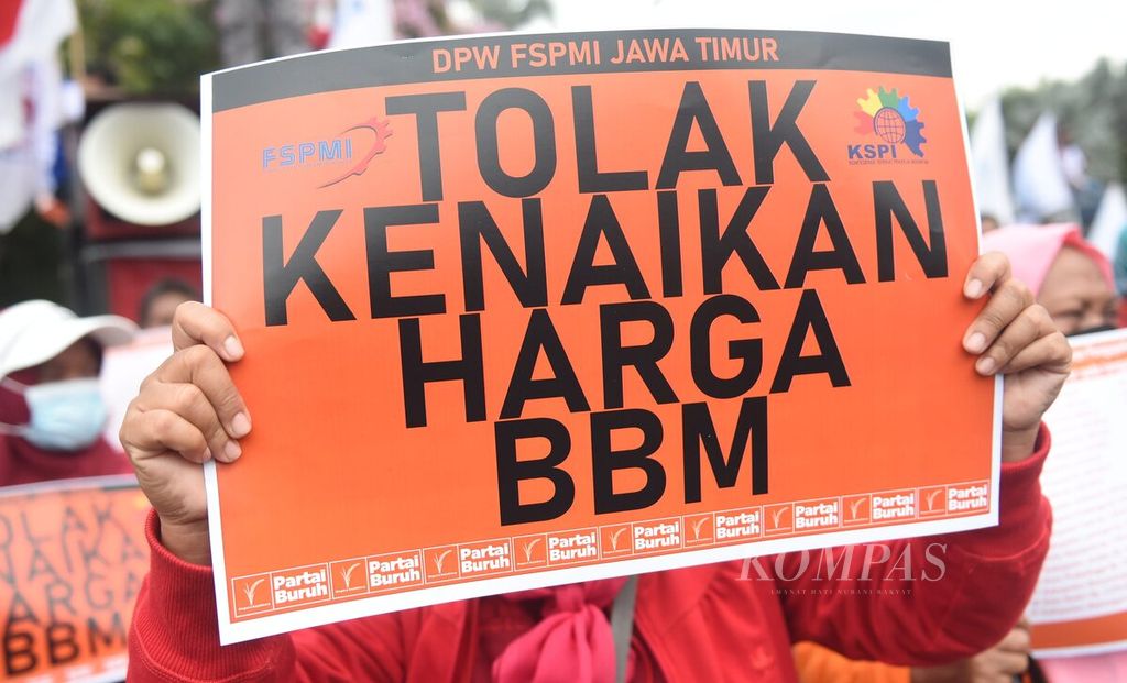 Buruh membawa poster tuntutan saat berunjuk rasa menolak kenaikan harga BBM di depan Gedung Negara Grahadi, Surabaya, Jawa Timur, Rabu (31/8/2022). 