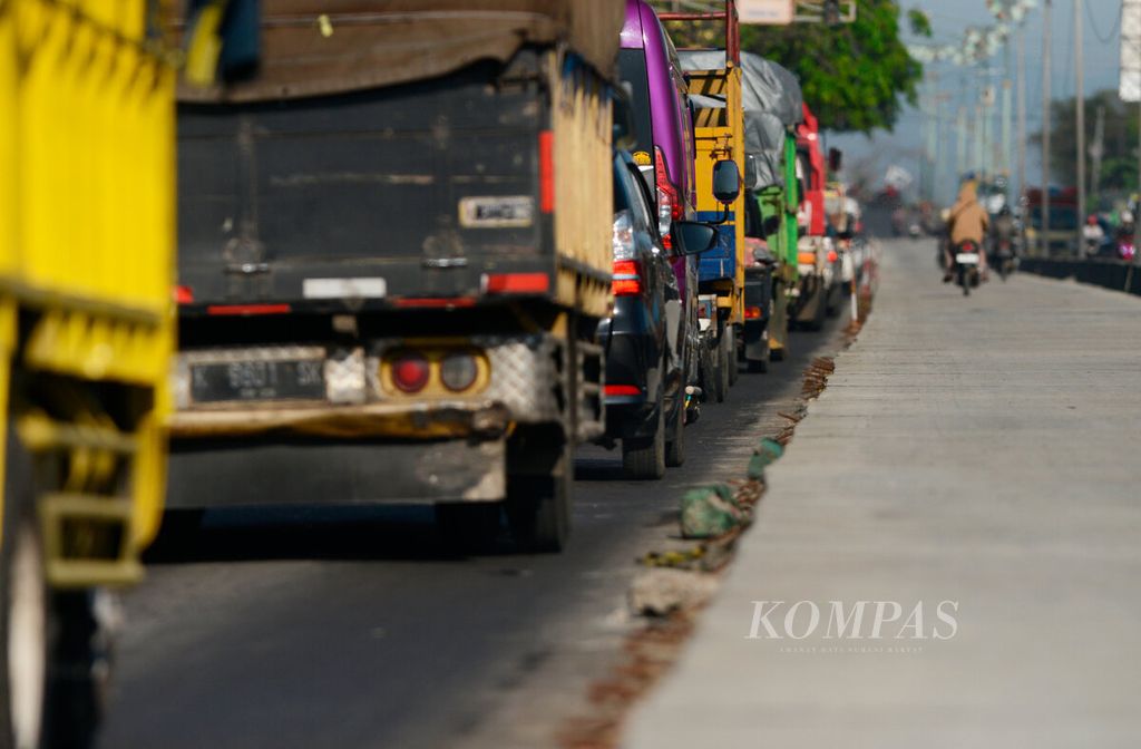 Antrean truk saat akan menuju Kota Semarang dengan melintasi jalur pantura yang sedang dalam perbaikan di Kecamatan Sayung, Kabupaten Demak, Jawa Tengah, Senin (10/7/2023). 