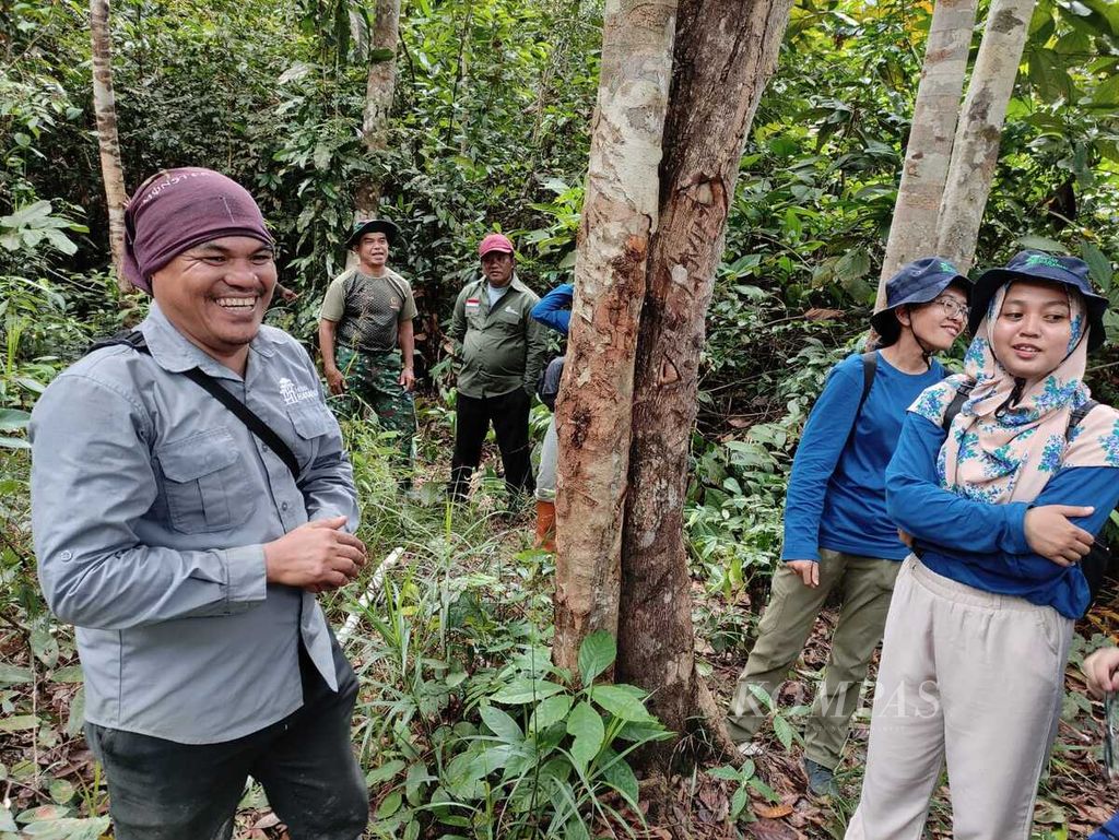 Beberapa penggemar K-pop bersenda gurau dengan Koordinator Senior Bisnis PT Restorasi Ekosistem Indonesia (Reki) Musadad saat mengunjungi Hutan Harapan di Jambi, Jumat (9/2/2024).