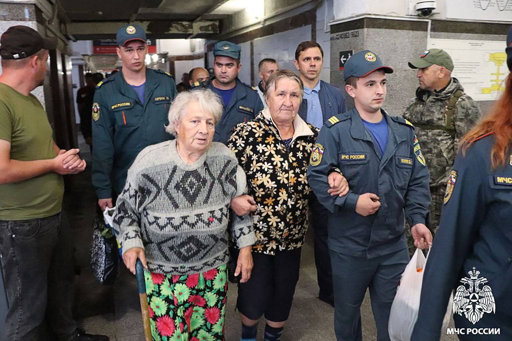 Dalam foto yang dirilis Kementerian Situasi Darurat Rusia menunjukkan personel kementerian membantu orang-orang yang dievakuasi dari permukiman perbatasan wilayah Kursk, Rusia barat daya, saat mereka tiba di stasiun kereta di Oryol, Rusia, 9 Agustus 2024.  