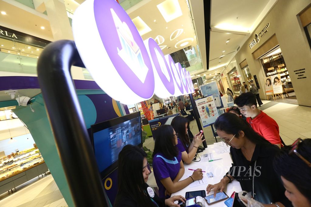 Petugas melayani nasabah yang hendak menambah jumlah saldo uang elektroniknya di gerai Ovo di pusat perbelanjaan di kawasan Kebayoran Lama, Jakarta Selatan, Jumat (29/11/2019). 
