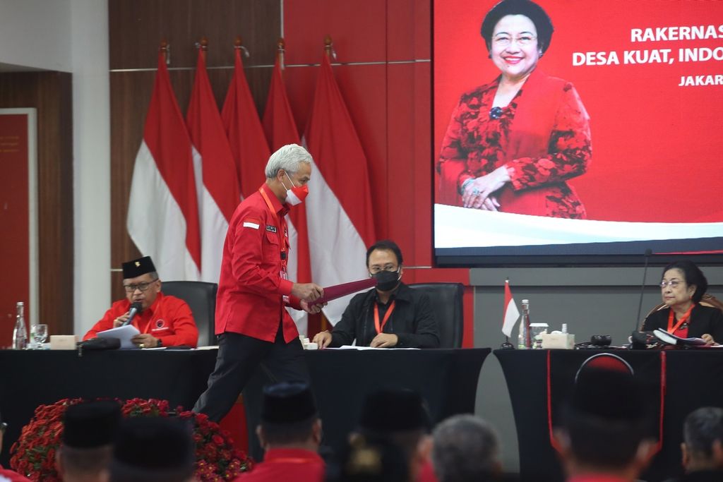 Gubernur Jawa Tengah Ganjar Pranowo (berdiri) memberikan hasil rekomendasi Rapat Kerja Nasional II kepada Ketua Umum DPP PDI-P Megawati Soekarnoputri (kanan) di Sekolah Partai PDI Perjuangan, Lenteng Agung, Jakarta, Kamis (23/6/2022).