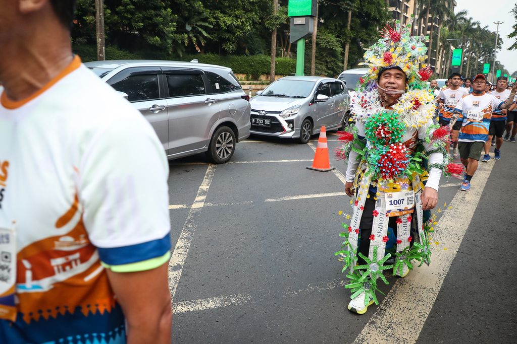 Peserta berkostum unik berlari dalam acara Run The City di Jalan Pintu Satu Senayan, Jakarta, Sabtu (1/7/2023). 