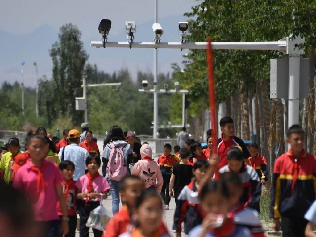 Dalam foto tanpa tanggal ini, anak-anak berjalan di bawah kamera pengawas di wilayah Xinjiang, China barat.