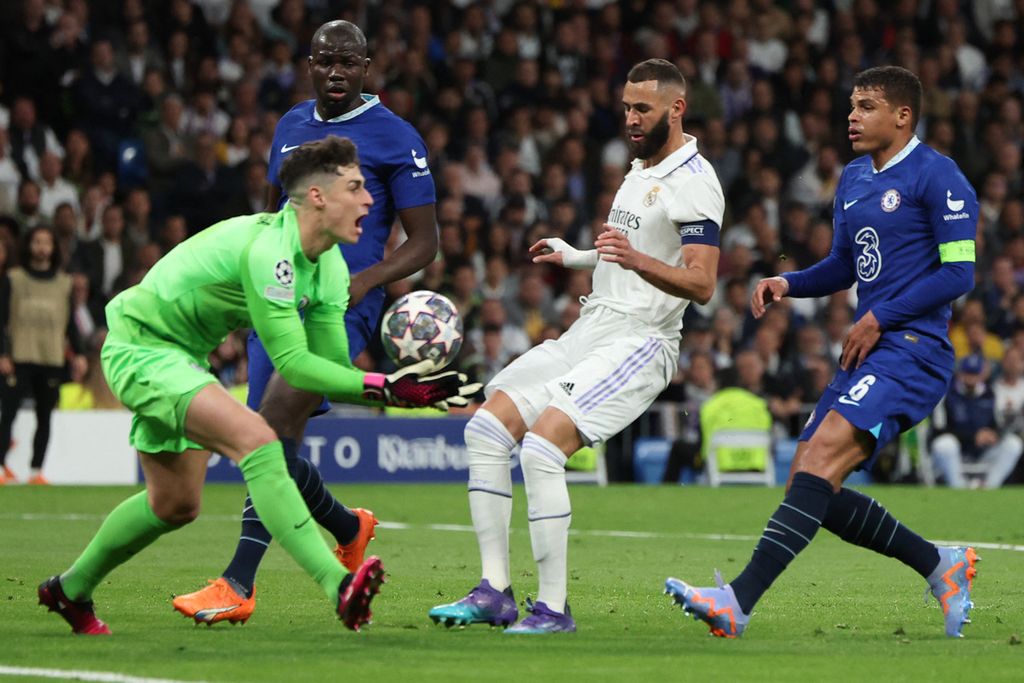 Kiper Chelsea Kepa Arrizabalaga (kiri) menangkap bola di depan pemain Real Madrid Karim Benzema (kedua dari kanan) pada laga pertama babak perempat final Liga Champions di Stadion Santiago Bernabeu, Madrid, Spanyol. Kamis (12/4/2023). Real Madrid menang 2-0 pada laga itu.