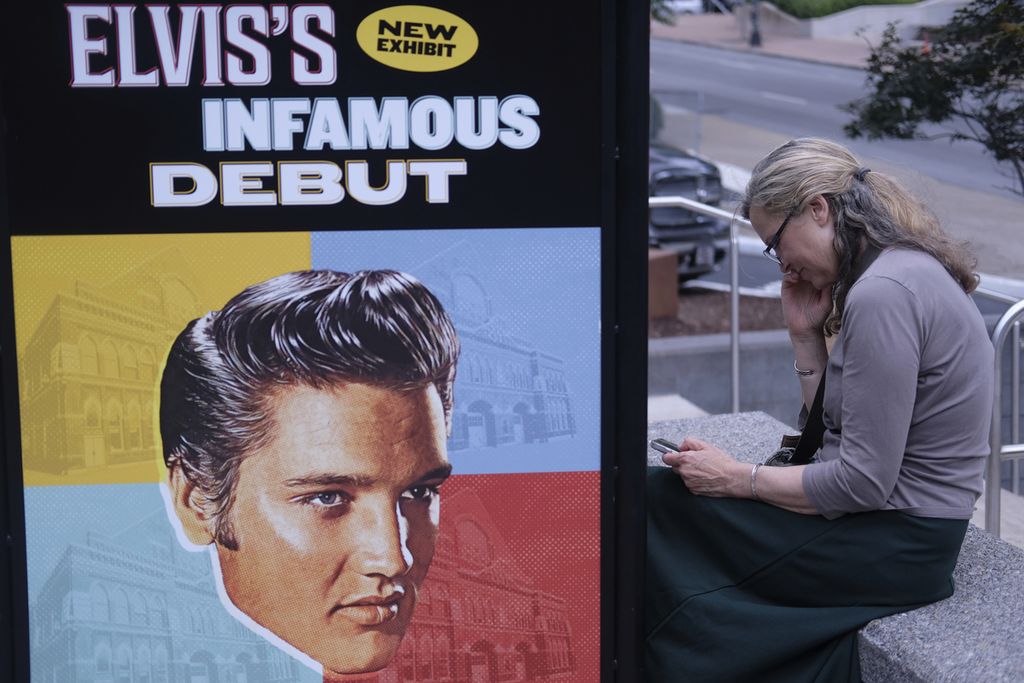 Sandra Morris duduk di luar Plaza Ryman, di depan poster peringatan penampilan Elvis Presley di lokasi konser di Nashville, Tennessee, Amerika Serikat, pada 30 Juli 2024. 