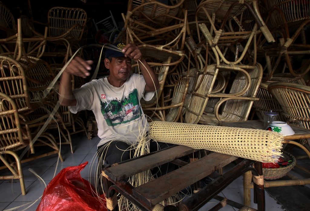 Ridwan (63), perajin rotan, menyelesaikan pembuatan alas kursi yang dilapisi rotan di bengkelnya, di daerah Grogol, Jakarta Barat, Kamis (23/10/2019). Kerajinan rotan tersebut ditawarkan pembeli dengan harga berkisar Rp 1 juta sampai Rp 1,5 juta.