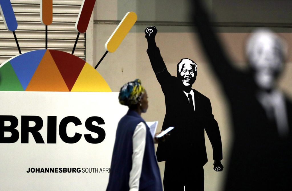 Seorang jurnalis melewati ornamen yang menggambarkan tokoh antiapartheid Afrika Selatan, Nelson Mandela, yang dipajang di arena pertemuan para menteri luar negeri negara anggota BRICS di Johannesburg, Afrika Selatan, Jumat (2/6/2023).
