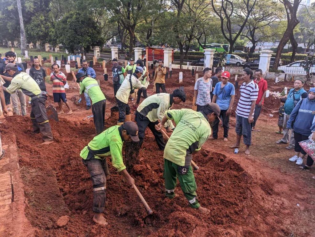 Petugas pemakaman menimbun tanah di kuburan Fajri di TPU Menteng Pulo, Kamis (22/6/2023).