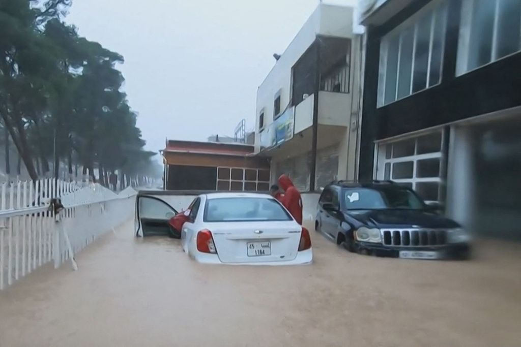 A photo from a video clip posted on the Facebook account of the Libyan Red Crescent on September 11, 2023 shows their team members assisting a driver whose car was hit by flooding in the city of Al-Bayda in eastern Libya.
