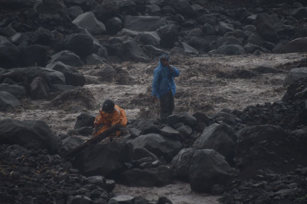 Di tengah banjir lahar hujan, Warga menambang pasir di aliran Besuksat yang berhulu di Gunung Semeru di Kecamatan Pasrujambe, Kabupaten Lumajang, Jawa Timur, Minggu (17/1/2021). Gunung Semeru pada Sabtu (16/1/2021) mengeluarkan material vulkanik sejauh 4,5 kilometer dari puncak. 