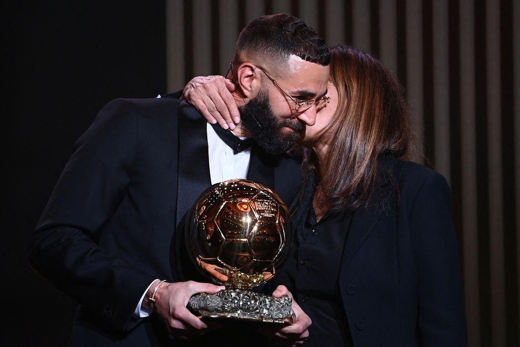 Ibu Karim Benzema, Malika Benzema, mencium pipi anaknya saat berada di panggung menemani Karim Benzema menerima Ballon d'Or, di Theatre du Chatelet, Paris, Perancis, Senin (17/12/2022) 