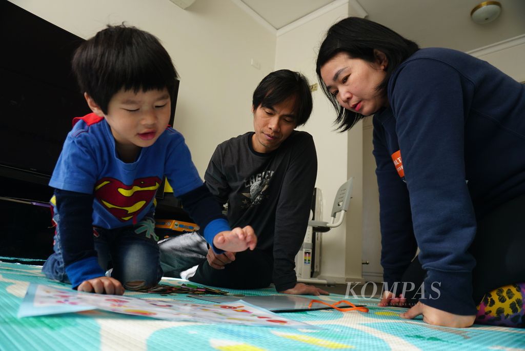 Martin Cahyo (45, tengah) dan Lily Lumintang (43) bermain dengan anak bungsu mereka, Raphael (3), di rumah mereka di Kew, di timur Melbourne, Australia, pada Sabtu (24/8/2024). 