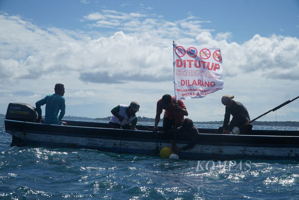 Nelayan memasang bendera penanda jeda tangkap di perairan Pulau Beriulou, Dusun Matotonan, Desa Sinaka, Kecamatan Pagai Selatan, Kepulauan Mentawai, Sumatera Barat, Sabtu (17/6/2023). 