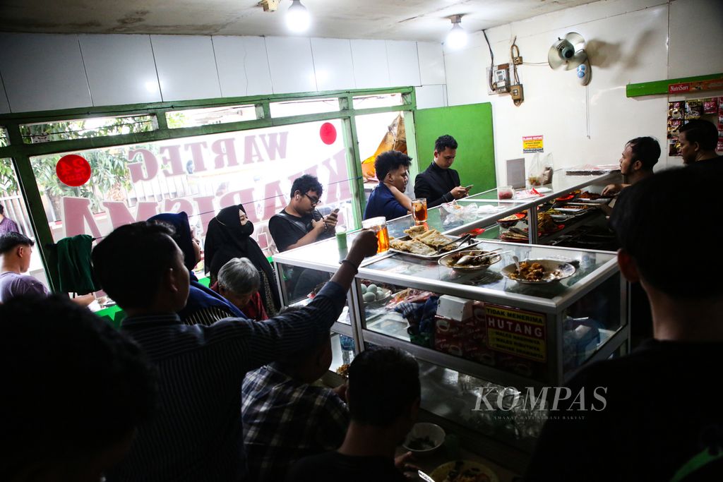 Suasana di dalam warteg yang dipenuhi pembeli saat jam makan siang di kawasan Kuningan, Jakarta Selatan, Selasa (27/2/2024). Tekanan ekonomi masyarakat Indonesia di awal tahun ini semakin berat dengan kenaikan harga bahan makanan pokok. 