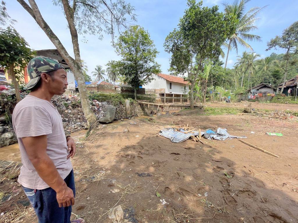 Yudhi, Ketua RT 002 Kampung Gununglanjung, Desa Cijedil, Kecamatan Cugenang, Kabupaten Cianjur, menatap lahan yang sempat dipenuhi tenda. Sebanyak lima tenda, termasuk tenda miliknya, terbawa hanyut banjir pada (20/3/2023). Lokasi pengungsian itu berada di samping Sungai Cibalagung.