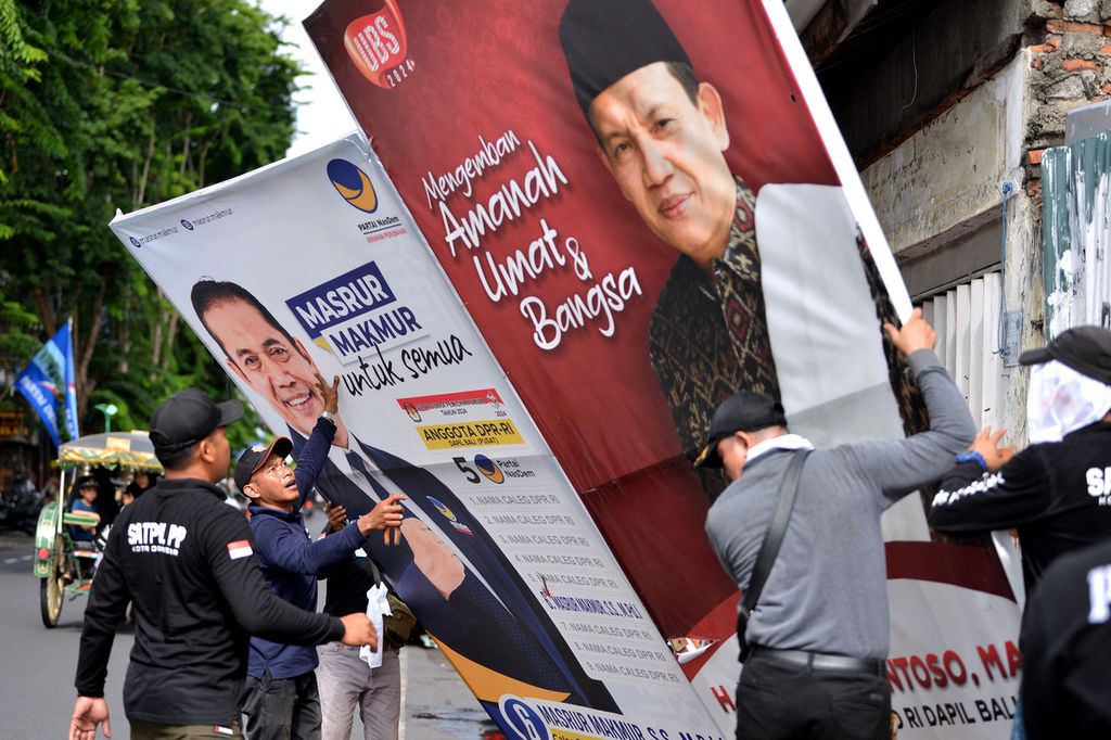Petugas Satpol PP Denpasar mencopot alat peraga kampanye Pemilu 2024 yang masih terpasang di Denpasar, Bali, Minggu (11/2/2024). Penurunan dan pembersihan alat peraga kampanye tersebut dilakukan memasuki tahapan masa tenang jelang pelaksanaan Pemilu pada 14 Februari. 