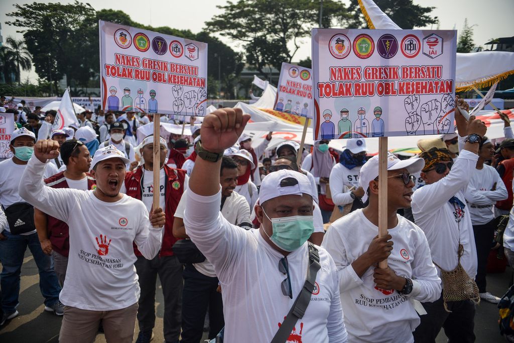Tenaga kesehatan mengepalkan tangan mereka saat aksi di depan gedung MPR/DPR/DPD, Jakarta Pusat, Senin (5/6/2023).  