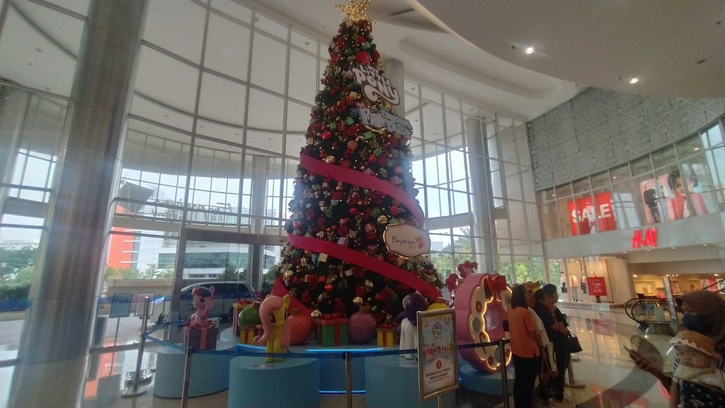 Sejumlah pengunjung tengah mengambil gambar di depan pohon Natal setinggi 10 meter terpampang di pintu utama Mall Emporium Pluit, Jakarta Utara, Rabu (7/12/2022).