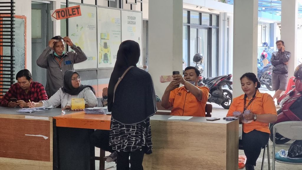 Petugas memotret penerima manfaat sebagai bukti penerimaan bantuan langsung tunai dari Pemerintah Kota Bandung di Kantor Pos Asia Bandung, Jalan Asia Afrika, Kota Bandung, Jawa Barat, Selasa (29/11/2022).