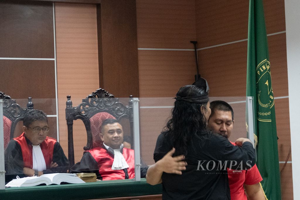 Ketua Umum Lembaga Swadaya Masyarakat (LSM) Gagak Hitam Arba Udin (berkemeja hitam) memeluk terdakwa kerusuhan demonstrasi Rempang, Iswandi, seusai sidang pemeriksaan saksi di Pengadilan Negeri Batam, Kepulauan Riau, Rabu (3/1/2024).