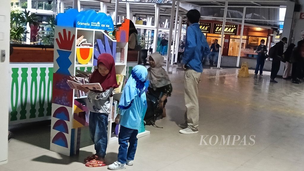 Dua kakak adik membaca buku dan memilih buku di perpustakaan mini Gramedia di Stasiun Besar Bogor, Jawa Barat, Sabtu (2/3/2024).