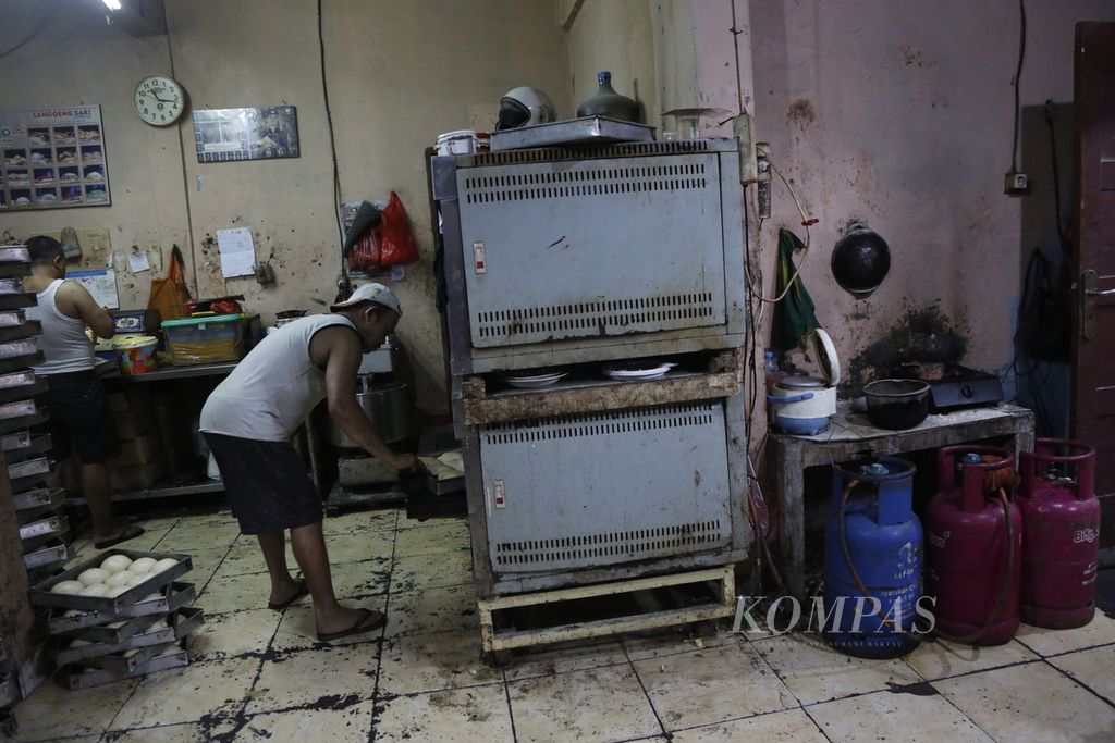 Pekerja memanggang roti ke dalam oven di sebuah UMKM pembuatan roti di kawasan Bendungan Hilir, Jakarta Pusat, Selasa (14/3/2023). 