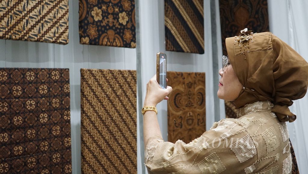 Pengunjung menyaksikan koleksi batik milik Pura Mangkunegaran dalam pergelaran "Angsukayana" di Pura Mangkunegaran, Kota Surakarta, Jawa Tengah, Minggu (29/10/2023).