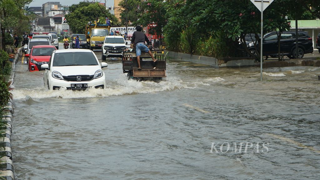 Banjir yang terjadi di Jalan R Soekamto, Palembang, Sumatera Selatan, Kamis (6/10/2022). Akibat pasang Sungai Musi dan cuaca ekstrem, sejumlah titik di Kota Palembang terendam. Kondisi ini menghambat aktivitas warga.