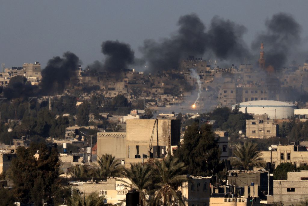 Foto yang diambil, Senin (15/1/2024), dari Rafah menunjukkan asap dan api terlihat dari Khan Yunis, Jalur Gaza selatan, menyusul serangan bom oleh Israel. 