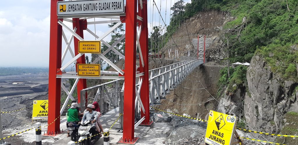 Minggu (24/4/2022), masyarakat melintasi jembatan gantung Gladak Perak di Lumajang, Jawa Timur. Jembatan yang sebelumnya putus terdampak erupsi Semeru pada 4 Desember 2021 itu kini sudah siap dilintasi pemudik sepeda motor pada Lebaran 2022.