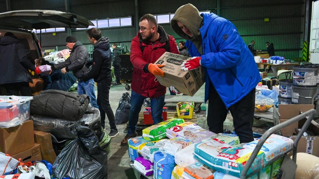 Relawan lokal menurunkan bantuan dari Hongaria dan Republik Ceko dari van di tempat pengumpulan makanan, obat-obatan, dan pakaian di Desa Solomonovo, Ukraina, barat Chop, dekat perbatasan Ukraina-Hongaria, pada Rabu (2/3/2022). 