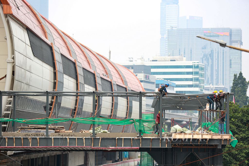 Aktivitas pekerja di proyek pembangunan jembatan penyeberangan orang untuk LRT di kawasan Kuningan, Jakarta Selatan, Jumat (24/6/2022). Proyek infrastruktur dann properti yang banyak terdapat di Jakarta mengundang para pekerja informal dari berbagai daerah untuk bekerja di Jakarta.