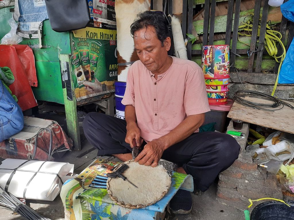 Sulaiman menjahit kulit hewan sebagai dasar pembuatan beduk di kawasan Pasar Tanah Abang, Jakarta Pusat, Kamis (13/4/2023). Ia berjualan beduk sejak tahun 2000.