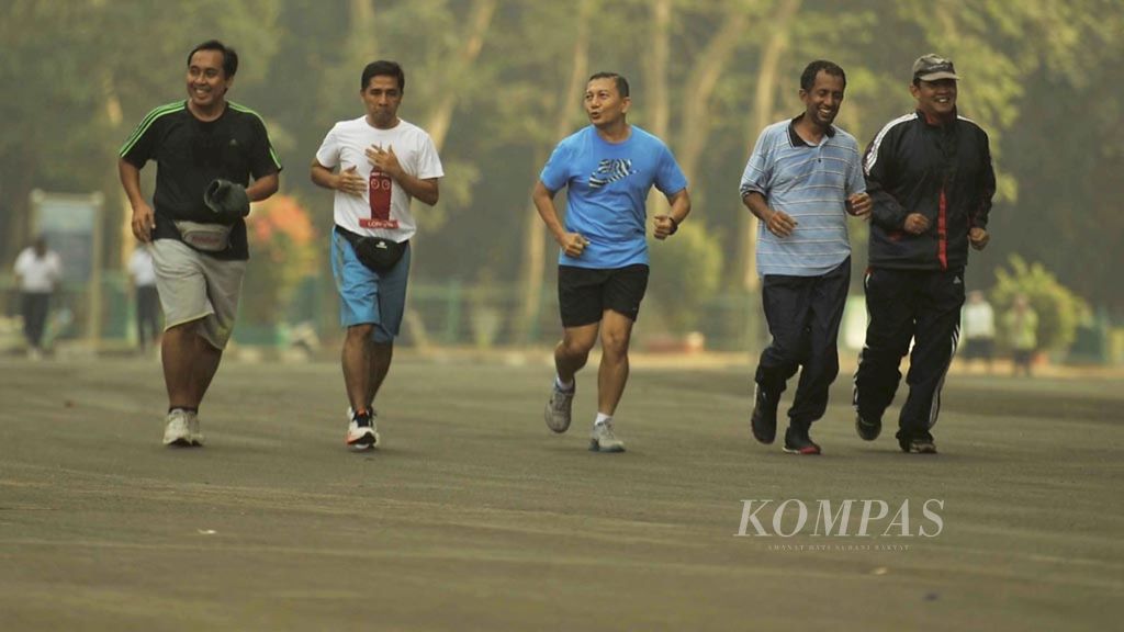 Residents exercise as thin morning haze still envelops the Gelora Bung Karno Complex in Senayan, Jakarta, on Tuesday (22/9/2015). Regular exercise and diet can reduce the risk of developing diabetes.