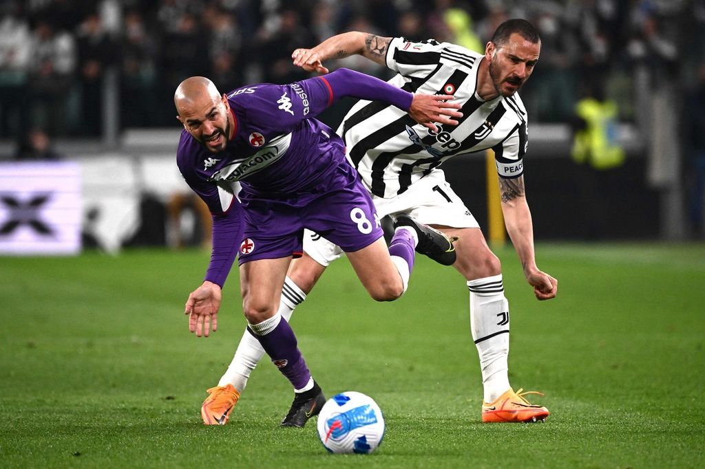 Pemain Fiorentina Riccardo Saponara (kiri) berebut bola dengan pemain Juventus Leonardo Bonucci pada laga kedua semifinal Coppa Italia, di Stadion Juventus, Turin, Kamis (21/4/2022) dini hari WIB. Juventus menang 2-0 dan unggul 3-0 secara agregat.