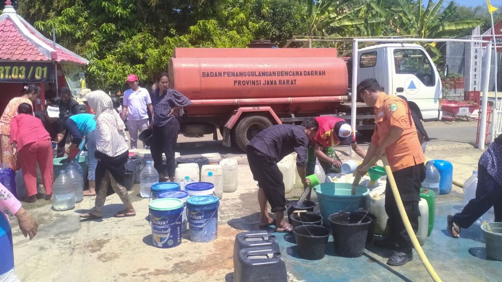 Petugas Badan Penanggulangan Bencana Daerah memberikan bantuan air bersih bagi warga di salah satu desa di Kabupaten Kuningan, Jawa Barat, yang terdampak kekeringan karena musim kemarau pada Agustus 2024. 