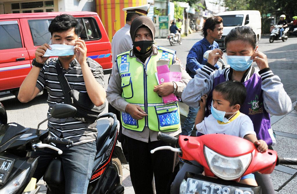 Polisi memberikan masker kepada warga saat razia warga tidak bermasker di Kecamatan Waru, Sidoarjo, Jawa Timur, Rabu (5/8/2020). Razia tersebut untuk mengingatkan kembali masyarakat bahwa pandemi Covid-19 belum berakhir dan protokol kesehatan yang telah ditetapkan harus selalu dipatuhi.